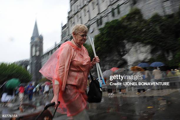 Pilgrims holds candles on her way to light them near the Grotto of Massbielle at the Sanctuary of Lourdes on September 11, 2008 ahead of the visit of...