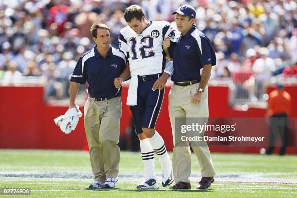 New England Patriots QB Tom Brady limping off field with trainers after taking hit to left knee from Kansas City Chiefs Bernard Pollard. Brady...