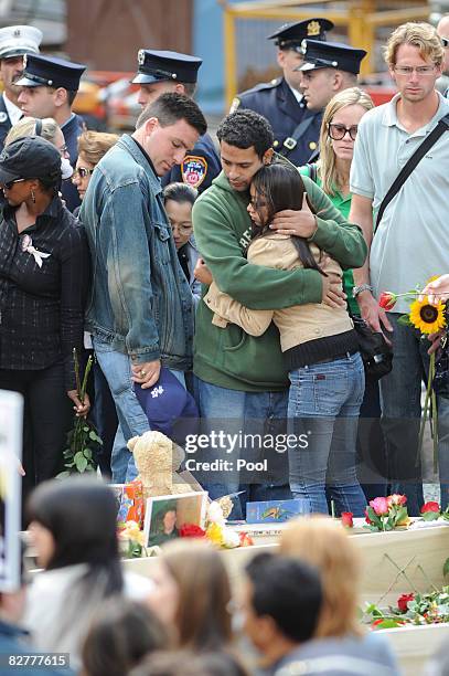 Young woman is embraced by a man at the foot of reflecting pool at Ground Zero during the 7th annual 9/11 memorial ceremony September 11, 2008 in New...