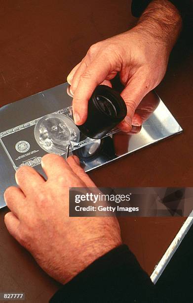 Bureau of Engraving and Printing employee examines the engraving plate for the 1996 $100 bill series at a Bureau of Engraving and Printing facility...