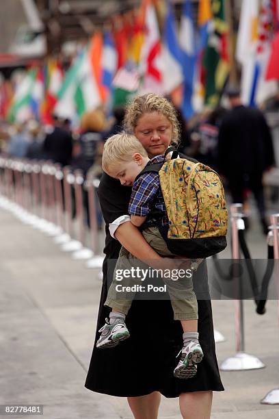 Woman carries a child during the 7th annual 9/11 memorial ceremony near Ground Zero September 11, 2008 in New York City. Family and friends of the...