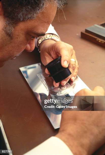 Bureau of Engraving and Printing employee examines the engraving plate for the 1996 $100 bill series at a Bureau of Engraving and Printing facility...