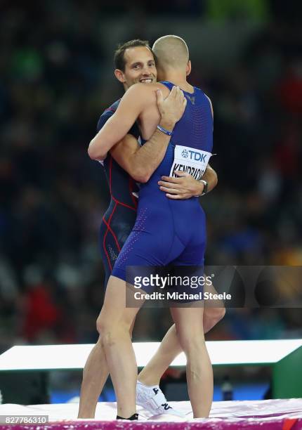 Sam Kendricks of the United States, gold, and Renaud Lavillenie of France, bronze, embrace at the conclusion of the Men's Pole Vault final during day...