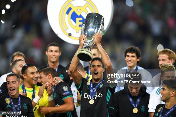 Real Madrid's French defender Raphael Varane holds the trophy after winning the UEFA Super Cup football match between Real Madrid and Manchester...