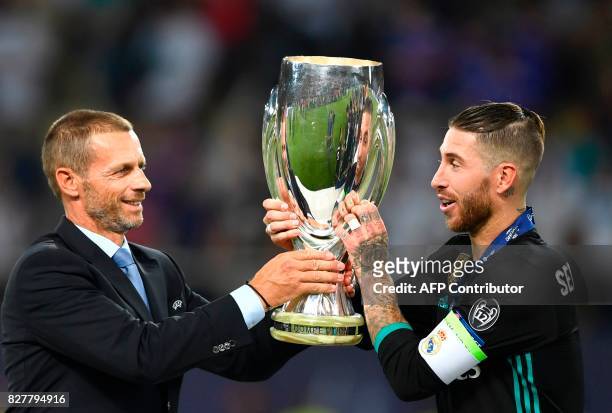 President Aleksander Ceferin gives the trophy to Real Madrid's Spanish defender Sergio Ramos after the UEFA Super Cup football match between Real...