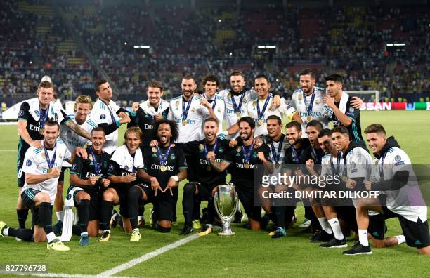 Real Madrid's players celebrate with the trophy after winning the UEFA Super Cup football match between Real Madrid and Manchester United on August 8...