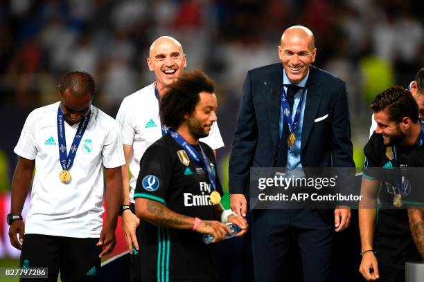 Real Madrid's French coach Zinedine Zidane and his assistant David Bettoni celebrate on the podium after winning the UEFA Super Cup football match...