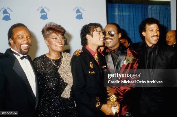 Michael Jackson and his producer Quincy Jones with Dionne Warwick, Stevie Wonder and Lionel Richie pose for photos backstage on February 25 1986 at...