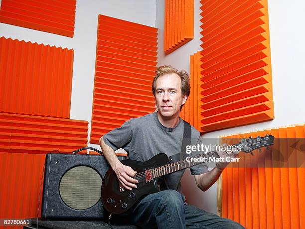 man playing guitar in studio - isolamento acustico foto e immagini stock