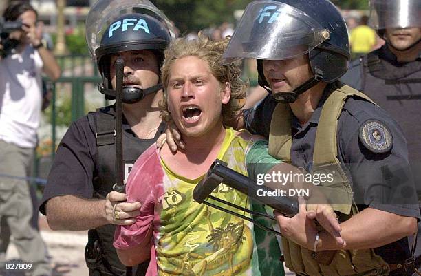 Argentine riot police drag away a demonstrator during clashes near the Casa Rosada government house December 20, 2001 in Buenos Aires. Economy...
