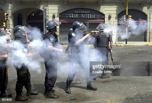 Riot police fire tear gas as they try to control a crowd of demonstrators December 20, 2001 in Buenos Aires, Argentina. Anger over Argentina's...