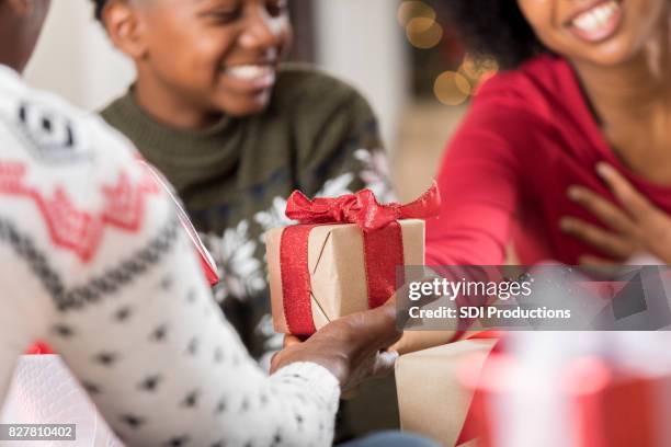 hombre da a hija adulta un regalo en navidad - dar fotografías e imágenes de stock