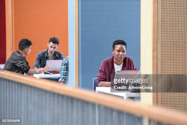 junge studentin mit laptop in modernen stand am college - training center stock-fotos und bilder