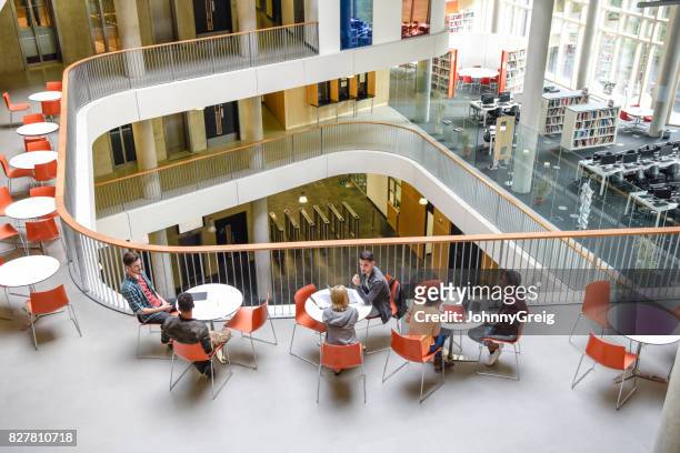 high angle view of modern college interior, students sitting around tables - modern school stock pictures, royalty-free photos & images
