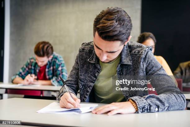 male college student doing exam - exam papers stock pictures, royalty-free photos & images