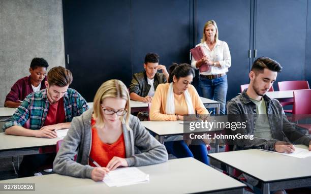 groep van studenten in het examen, leraar kijken - examen stockfoto's en -beelden