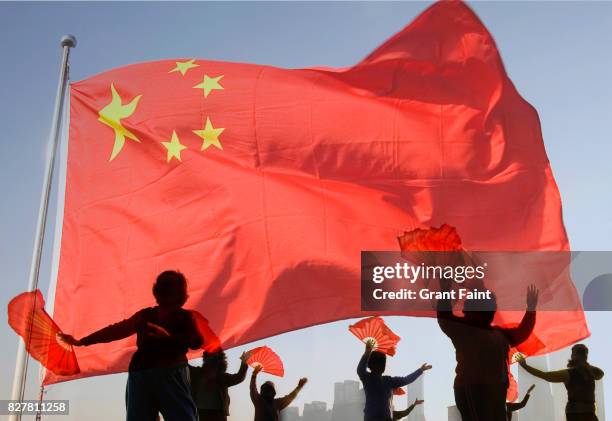 women doing morning tai chi exercises with chinese flag. - freedom fighter stock pictures, royalty-free photos & images