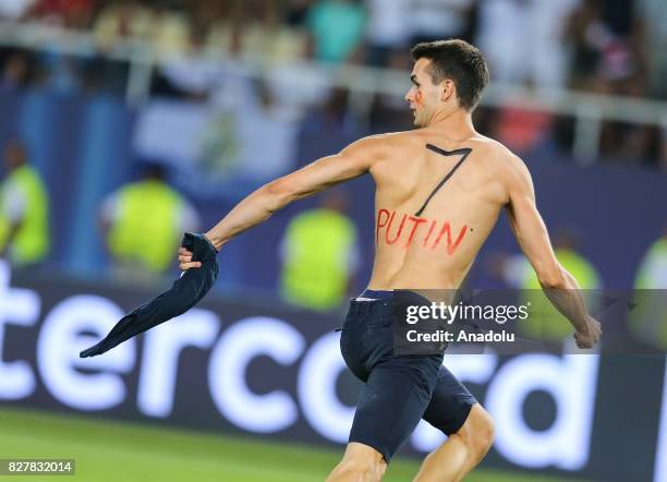 Fan with "7" and "Putin" written on his back enters the pitch after Real Madrid wins the UEFA Super Cup title in the final match against Manchester...