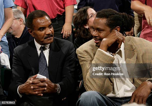 Former NFL player Calvin Hill speaks with former NBA player Sam Perkins during a time-out during the Indiana Fever's game with the New York Liberty...