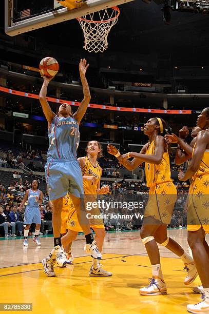 Jennifer Lacy of the Atlanta Dream goes up for a layup while Didney Spencer and Lisa Leslie of the Los Angeles Sparks watch during a game on...