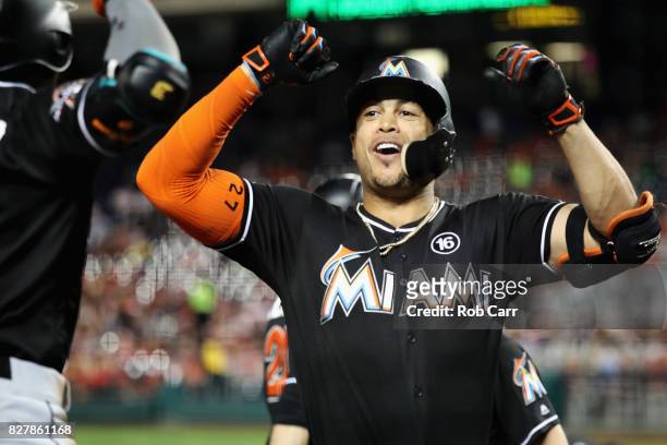 Giancarlo Stanton of the Miami Marlins celebrates with Dee Gordon after hitting a three run home run against the Washington Nationals in the fifth...