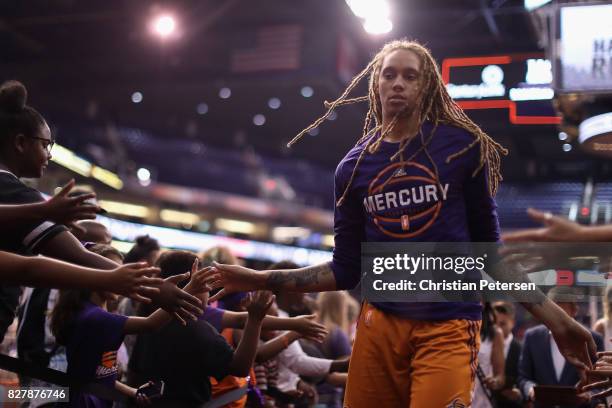 Brittney Griner of the Phoenix Mercury high fives fans as she walks off the court following the first half of the WNBA game against the San Antonio...