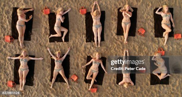 aerial view of woman sunbathing on beach in different positions - buxom blonde fotografías e imágenes de stock