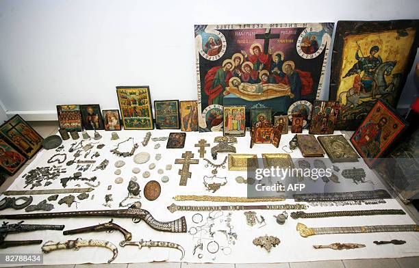 Orthodox icons, 19th century weapons and jewellery confiscated from four men in the northern Greek town of Serres, are displayed at the police...