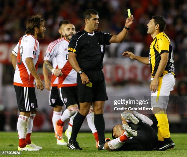 Referee Roddy Zambrano shows a yellow card to Luis Alberto Cabral of Guarani during a second leg match between River Plate and Guarani as part of...
