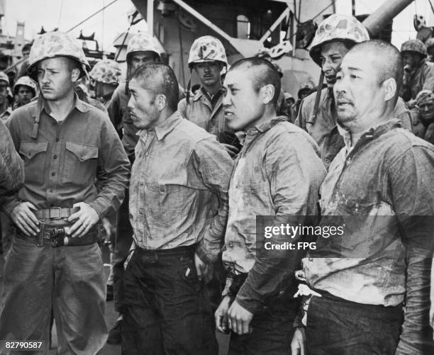 The first group of Japanese prisoners of war to be captured during the Battle of Iwo Jima, are taken aboard a US attack transport ship, February 1945.