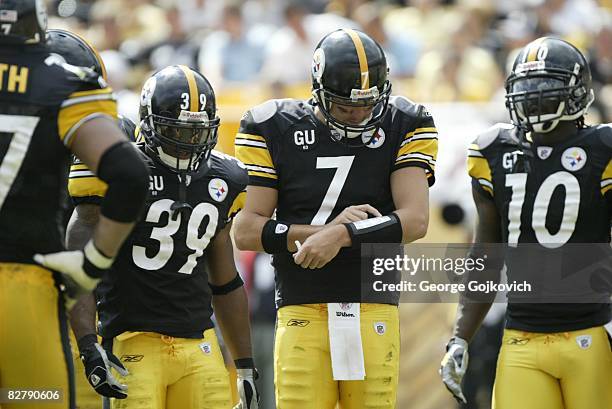 Quarterback Ben Roethlisberger of the Pittsburgh Steelers looks at a list of plays taped to his wrist while standing next to running back Willie...