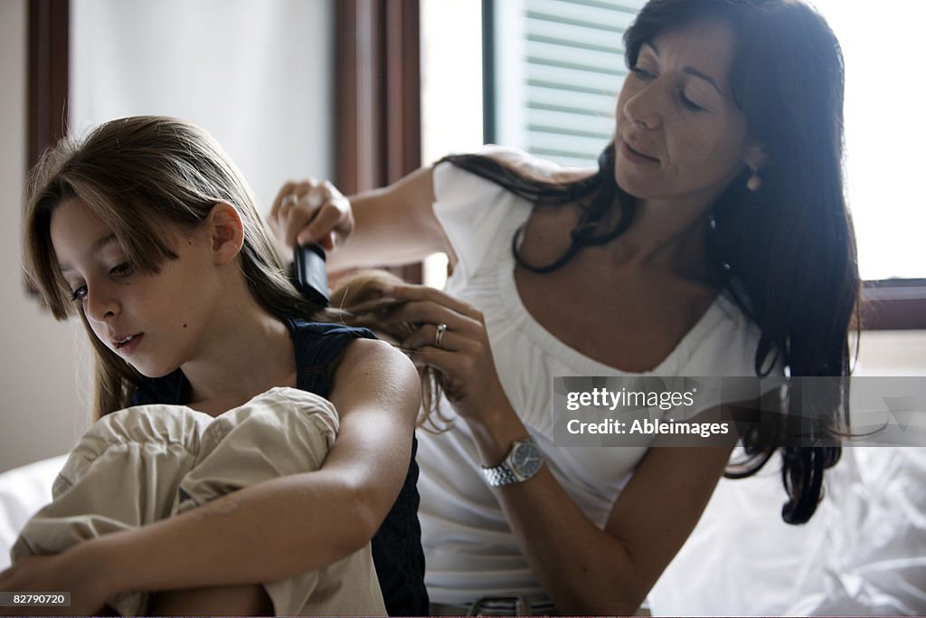 Mother brushing daughters hair