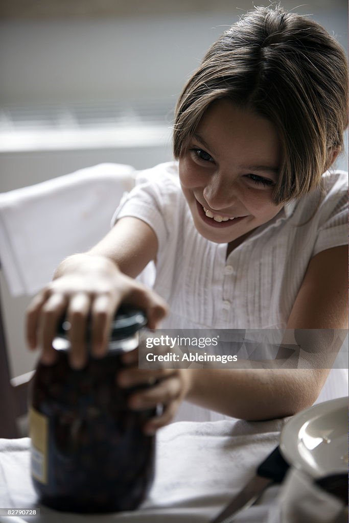 Girl opening jar of olives