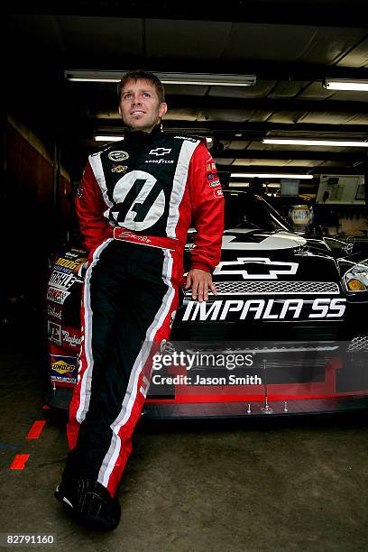 Scott Riggs, driver of the State Water Heaters Chevrolet, stands in the garage area prior to practice for the NASCAR Sprint Cup Series Sylvania 300...