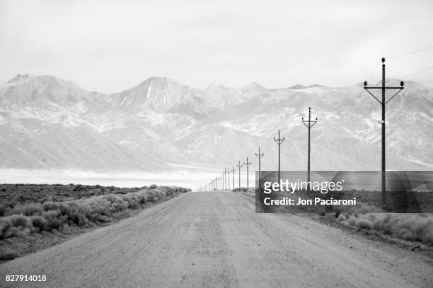 infrared long exposure of a lone road and power lines leading into the san juan mountain range. - condado del norte imagens e fotografias de stock
