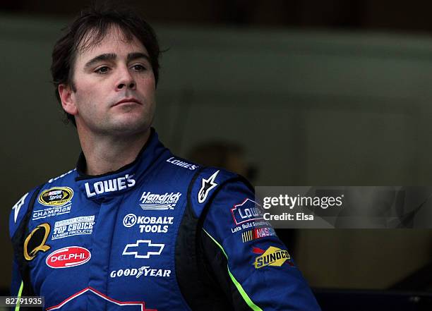 Jimmie Johnson, driver of the Lowe's Chevrolet, stands in his garage during practice for the NASCAR Sprint Cup Series Sylvania 300 at New Hampshire...