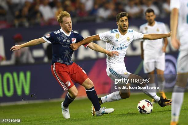 All-Star and Chicago Fire Midfielder Dax McCarty and Real Madrid midfielder Marco Asensio battle for the ball in the second half during a soccer...