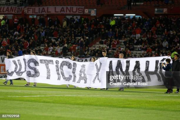 People hold a banner to demand justice for the femicide of 16-year-old Anahí Benitez in Buenos Aires prior a second leg match between River Plate and...