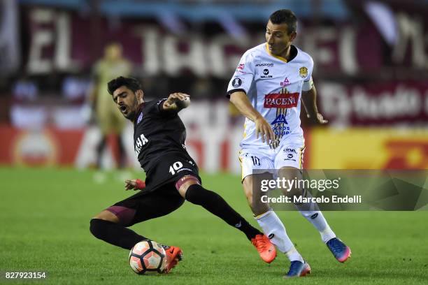 Roman Martinez of Lanus fights for ball with Pablo Escobar of The Strongest during the second leg match between Lanus and The Strongest as part of...