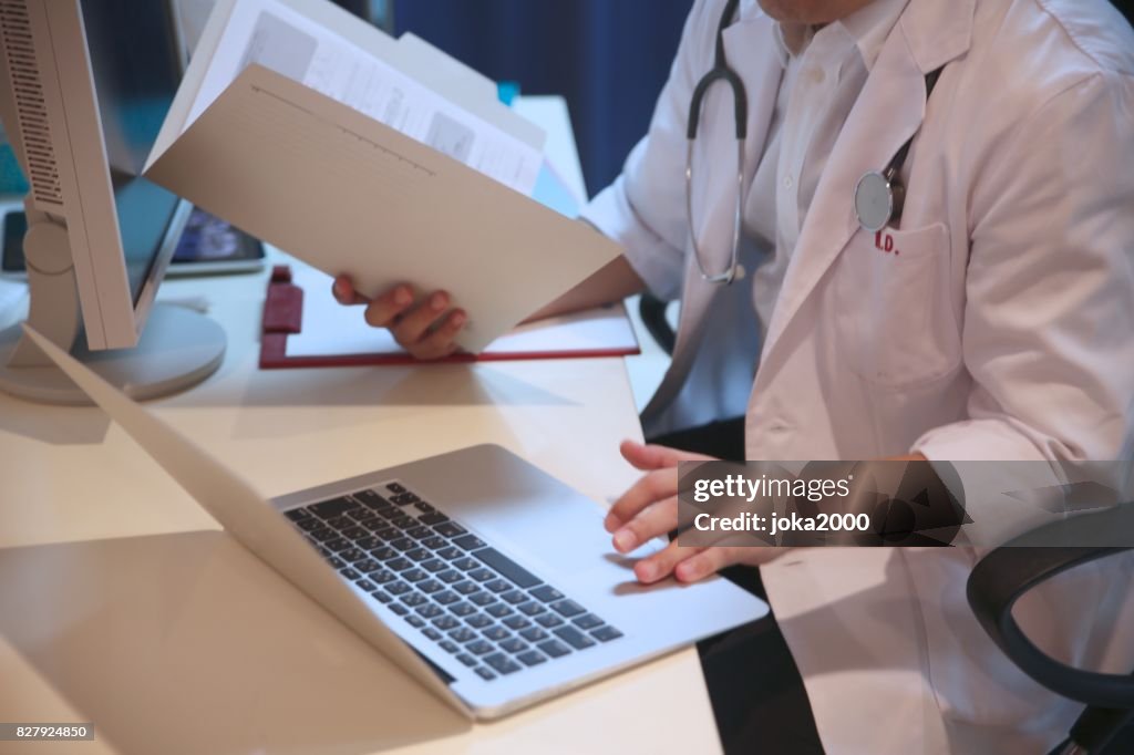 Japanese male doctor checking documents