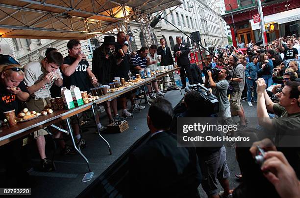 Competitive eaters scarf down cannolis at the Annual Cannoli Eating Contest during the Feast of San Gennaro in Little Italy September 12, 2008 in New...