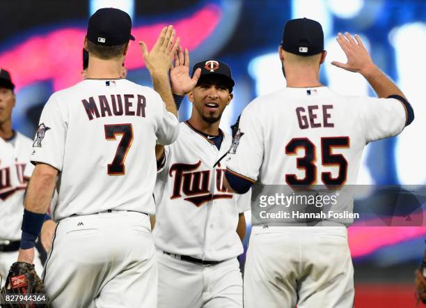 Joe Mauer, Eddie Rosario and Dillon Gee of the Minnesota Twins celebrate winning against the Milwaukee Brewers after the game on August 8, 2017 at...