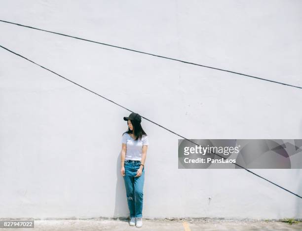 young woman in front of white wall - blank t shirt model stock pictures, royalty-free photos & images
