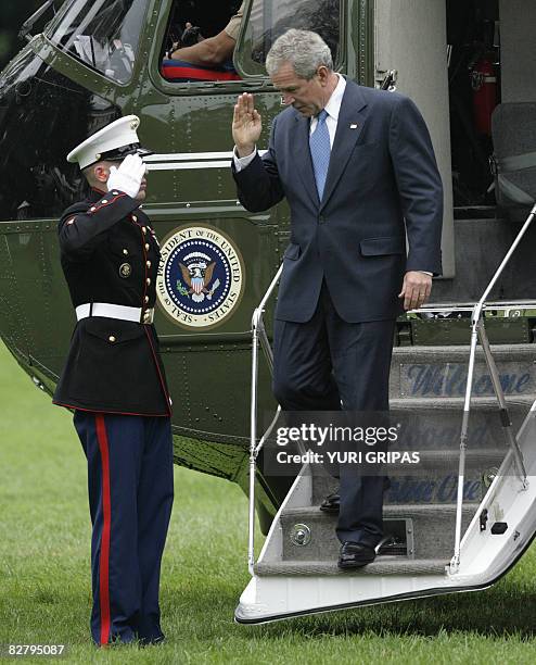 President George W. Bush salutes from the steps of the Marine helicopter on the South Lawn of the White House upon his return to Washington, DC on...