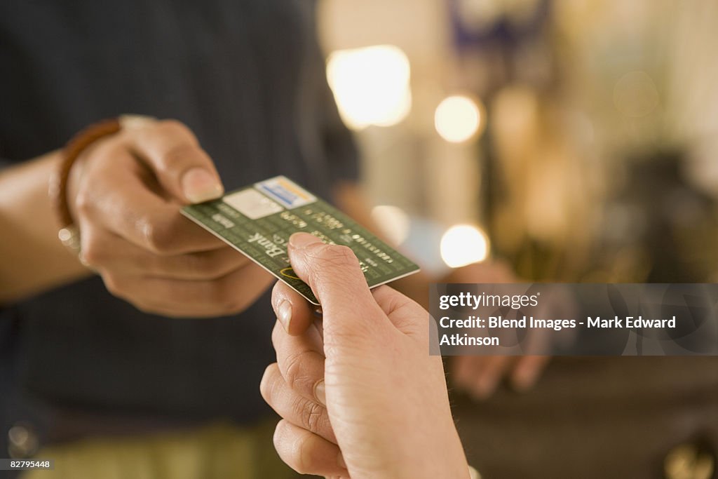 Mixed race woman handing credit card to cashier