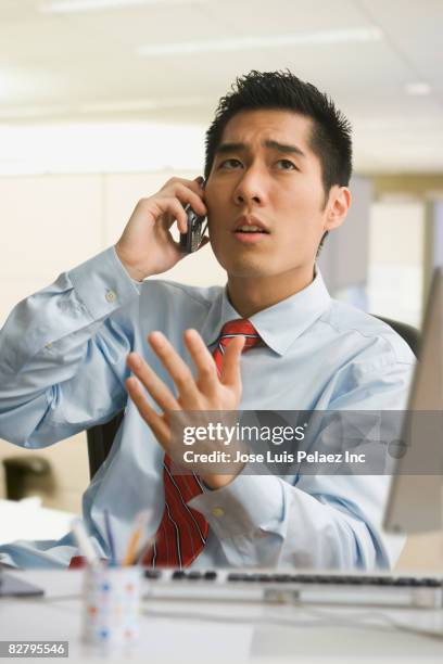 korean businessman on cell phone looking stressed - peuple eurasien photos et images de collection