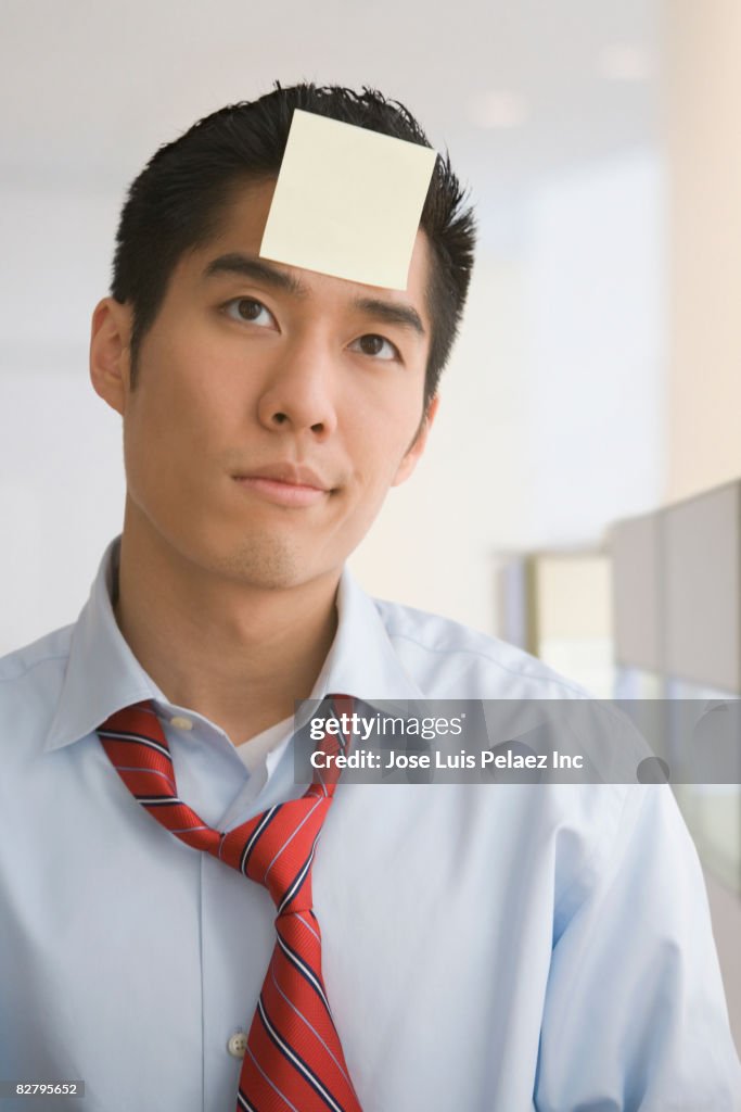 Korean businessman with sticky note on forehead