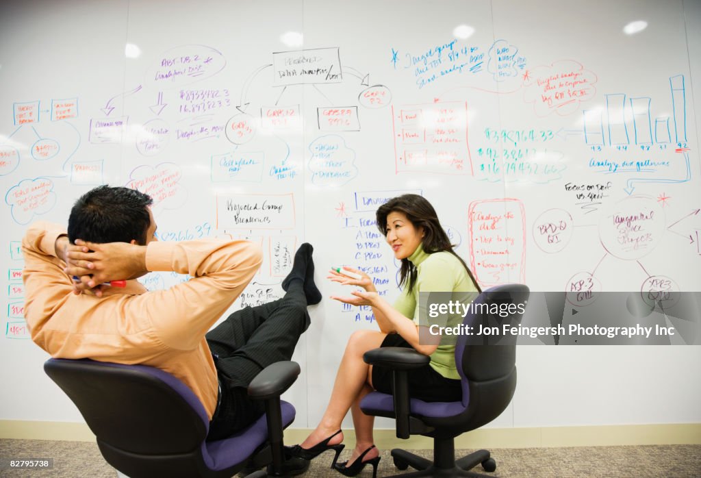 Multi-ethnic business people brainstorming on whiteboard