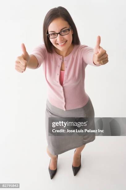 mixed race businesswoman giving thumbs up - happy woman thumbs studio ストックフォトと画像