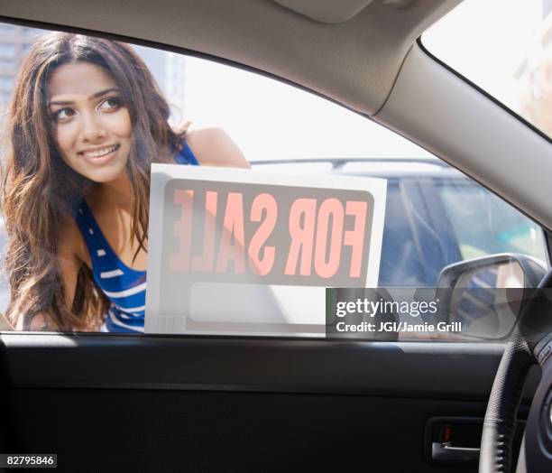 middle eastern woman looking at car for sale - comprar coche fotografías e imágenes de stock